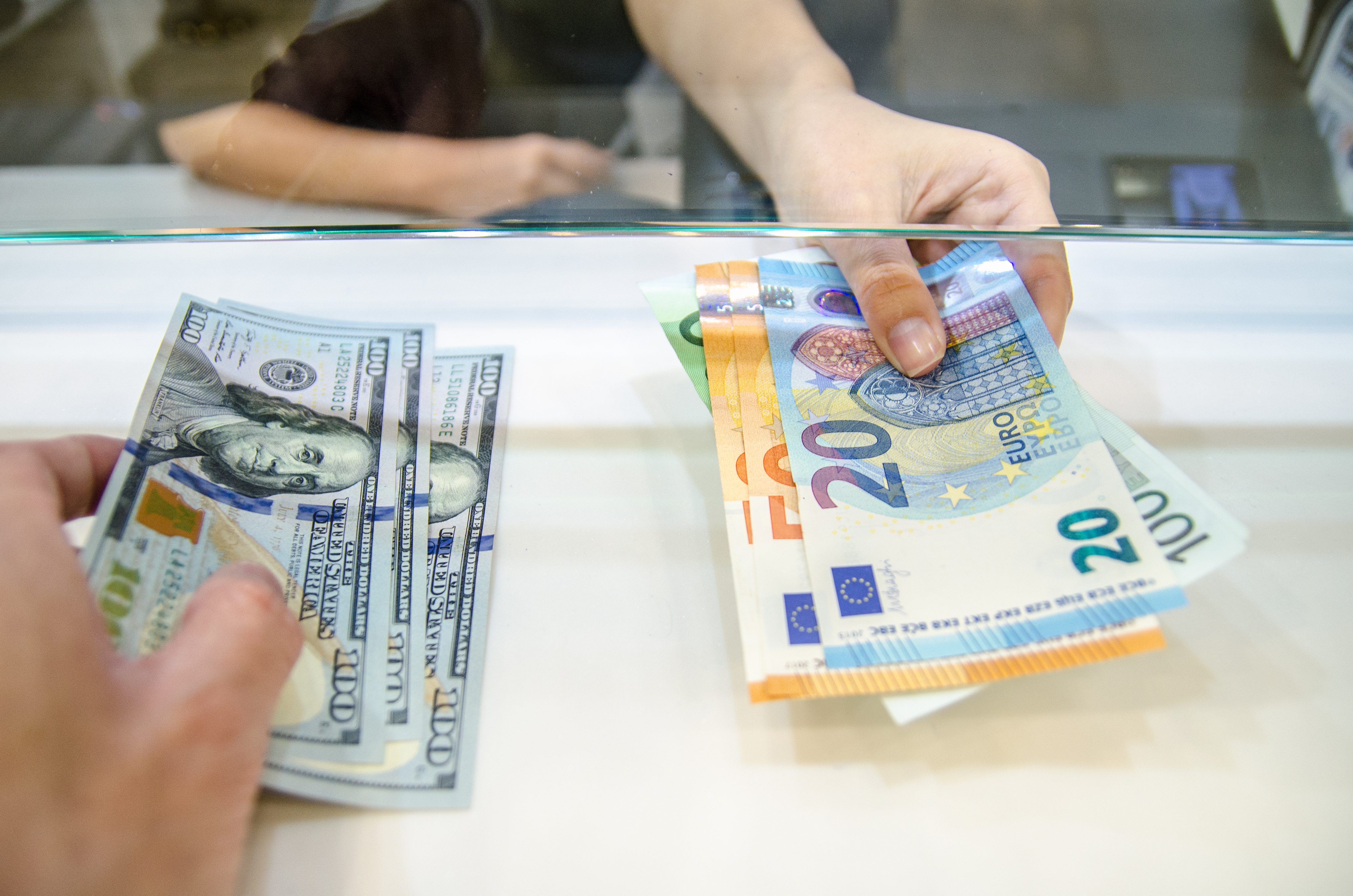 Exchange money, Exchange US dollar or American dollars (USD) for EUR money, A man and women are exchanging dollars for euros.